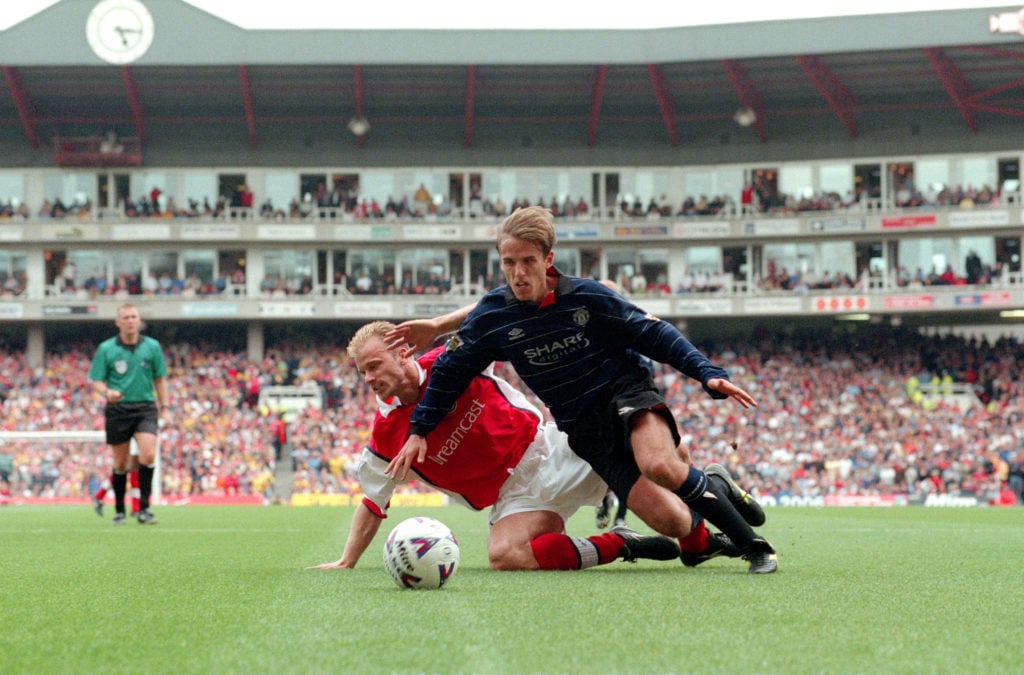 22 August 1999 - Premiership Football - Arsenal v Manchester United - Dennis Bergkamp of Arsenal goes down under a challenge from Phil Neville of M...