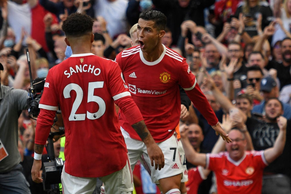 Manchester United's Portuguese striker Cristiano Ronaldo (R) celebrates with Manchester United's English striker Jadon Sancho (L) after scoring the...