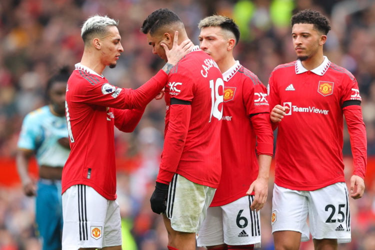 Casemiro of Manchester United is consoled by teammate Antony after being shown a red card during the Premier League match between Manchester United...