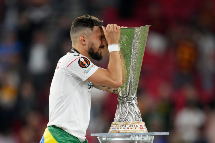 Alex Telles of Sevilla FC interacts with the UEFA Europa League trophy as they collect their winners medal after defeating AS Roma in the penalty s...