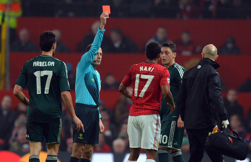 Turkish referee Cuneyt Cakir (2L) shows Manchester United's Portuguese midfielder Nani (3R) the red card to send him off during the UEFA Champions ...