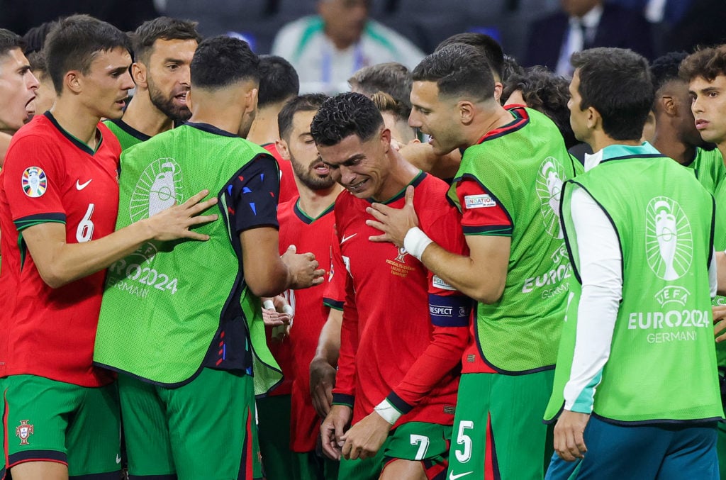 Cristiano Ronaldo of Portugal in tears is comforted by teammate Diogo Dalot during the break before extra time during the UEFA EURO 2024 round of 1...