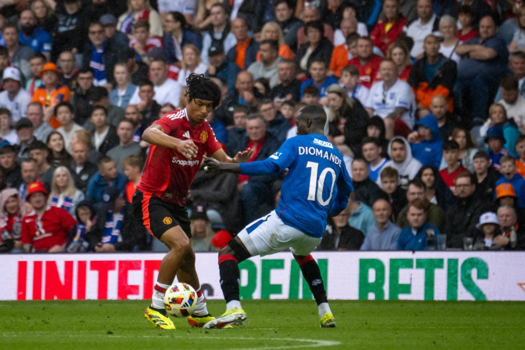 Maxi Oyedele of Manchester United is challenged for the ball by Mohamed Diomande of Glasgow Rangers during a pre-season friendly match between Manc...